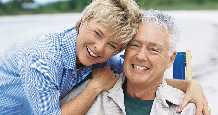Retired couple gets close and smiles to reveal their dental implants